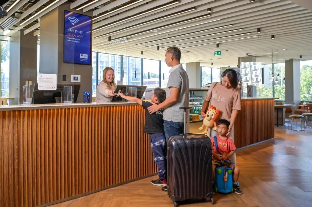Reception at Holiday Inn Express Sydney Airport with a family checking in